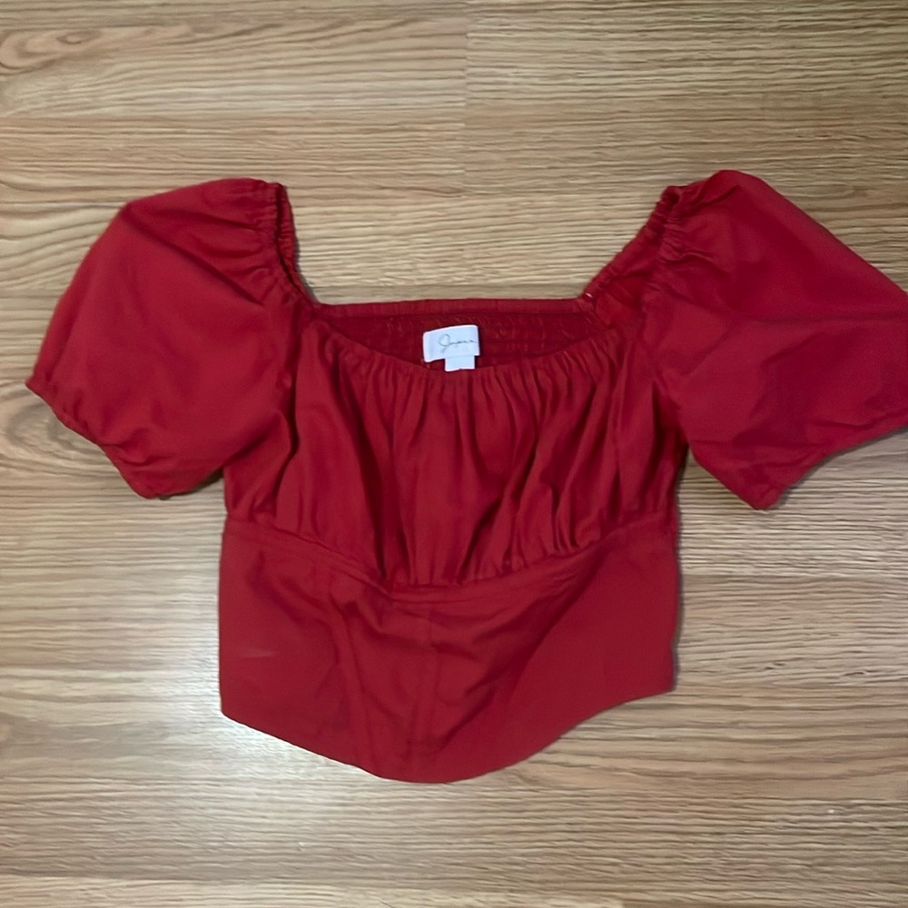 Red corset top. Puffy sleeves.